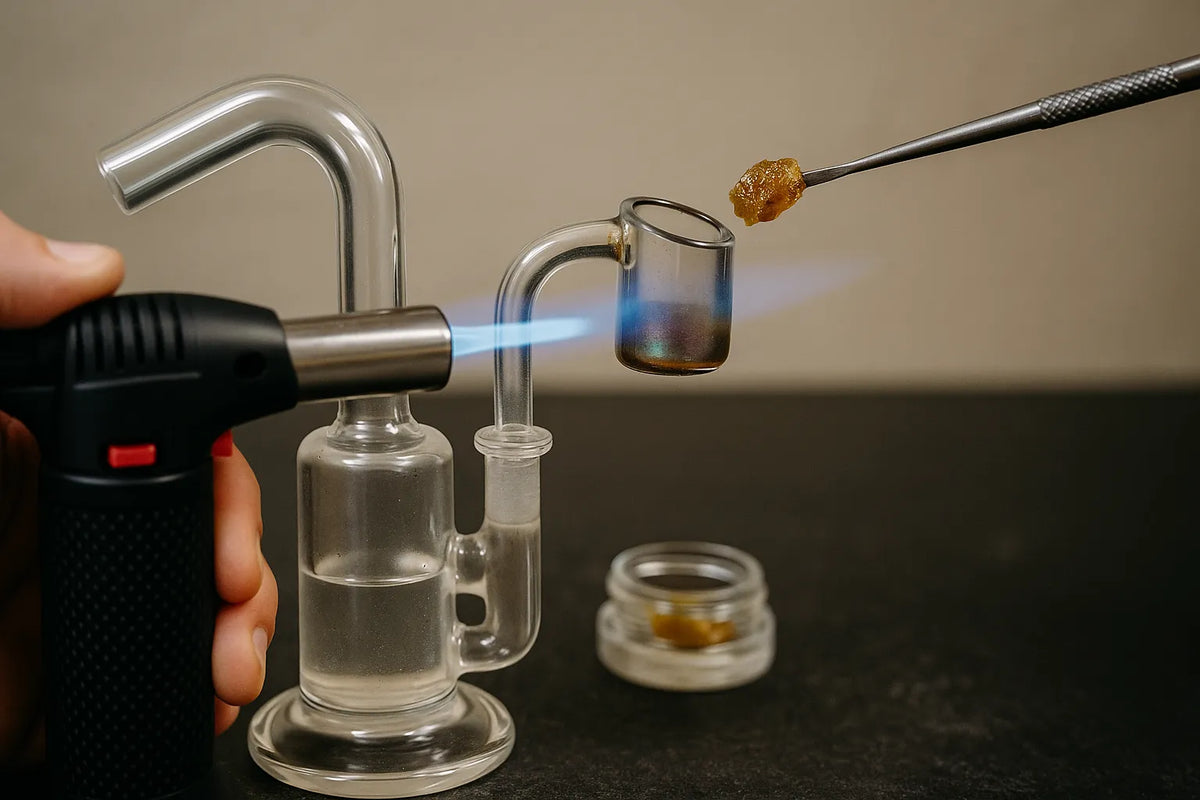 Una persona che usa un dab rig per inalare concentrato di Cannabis, vista ravvicinata in un ambiente domestico rilassato.